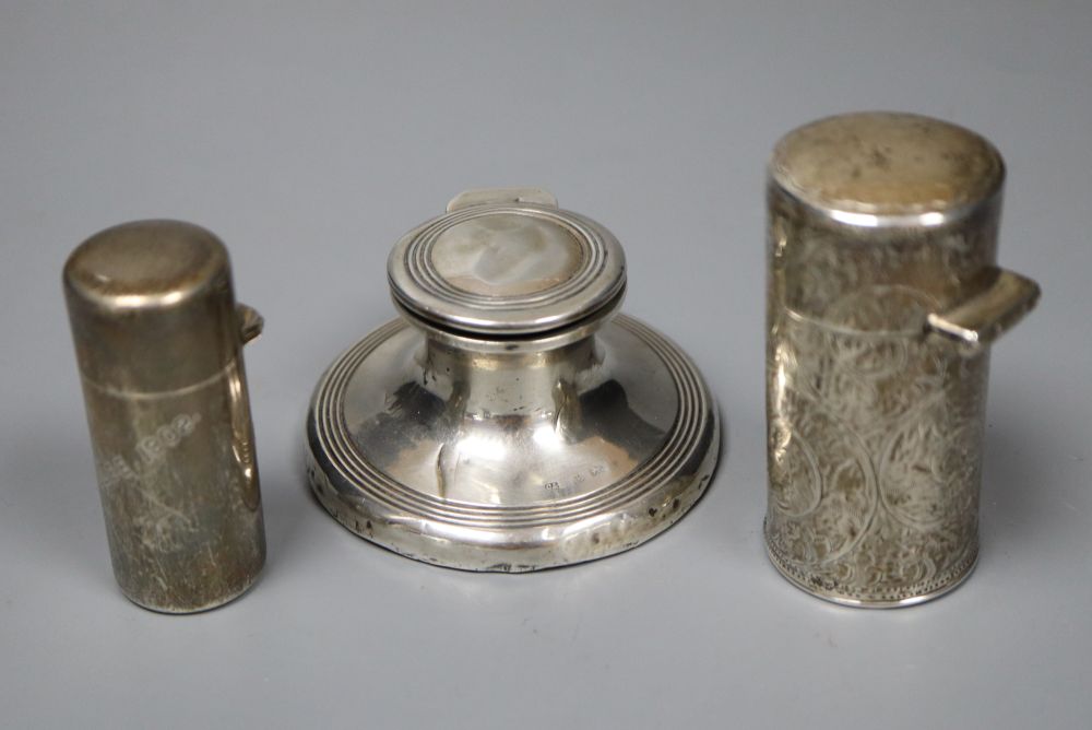 A silver capstan inkwell and two silver-cased cylindrical scent bottles